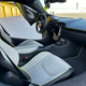 View of the passenger side of the interior of a Flux Green McLaren Artura with the door open.